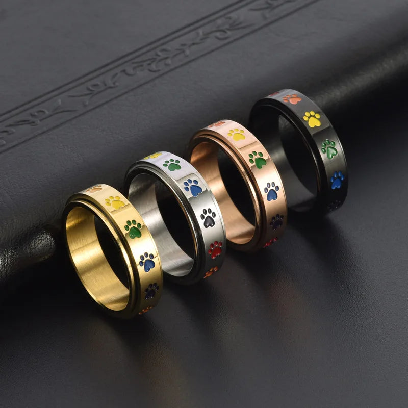 Thea - Anillo antiestrés giratorio con huellas de colores