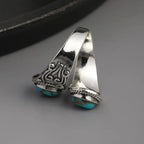 Elegante anillo de banda vintage con cruz y turquesa